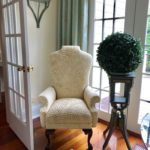 Wing Chair In Cremepair Of Pedestals With Boxwoods Copy